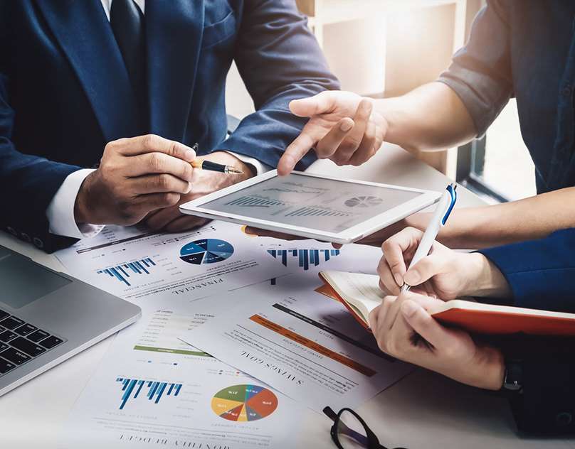 A group of business individuals engaged in discussion at a table, concentrating on financial services in dubai.